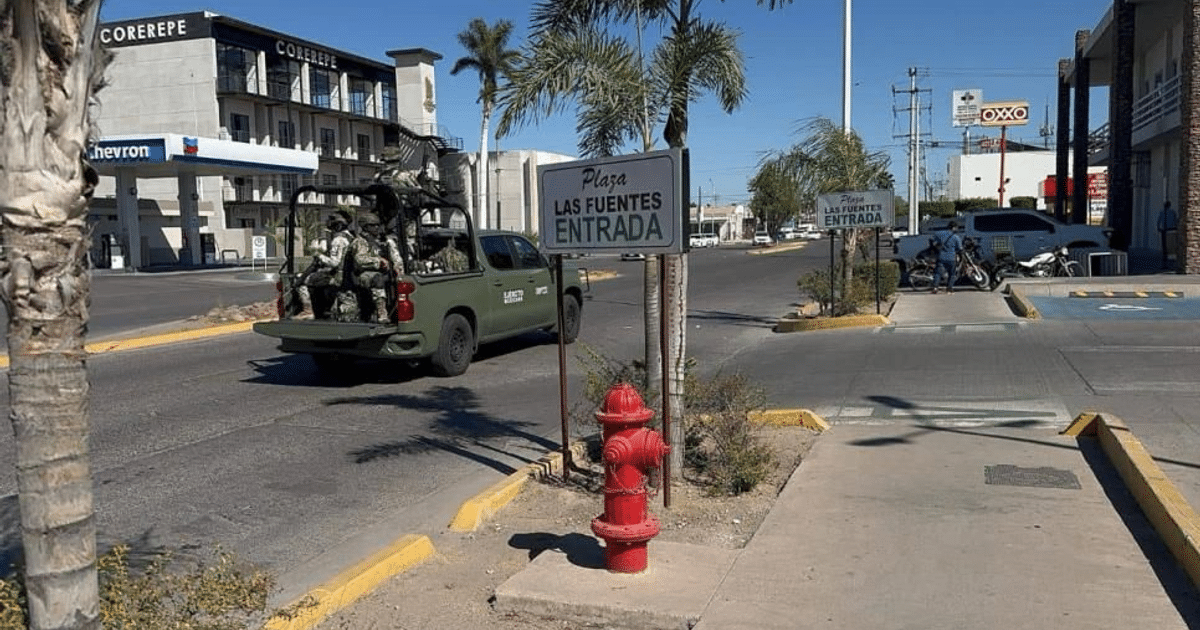 Calle con camión verde, plaza Las Fuentes, boca de incendios roja y motocicletas estacionadas