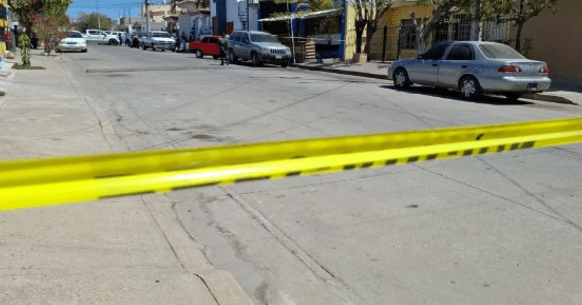 Calle en Culiacán acordonada con cinta amarilla tras incidente violento, con vehículos y edificios alrededor.