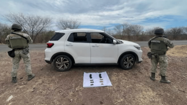 Vehículo blanco incautado en Culiacán con militares inspeccionando y objetos en el suelo