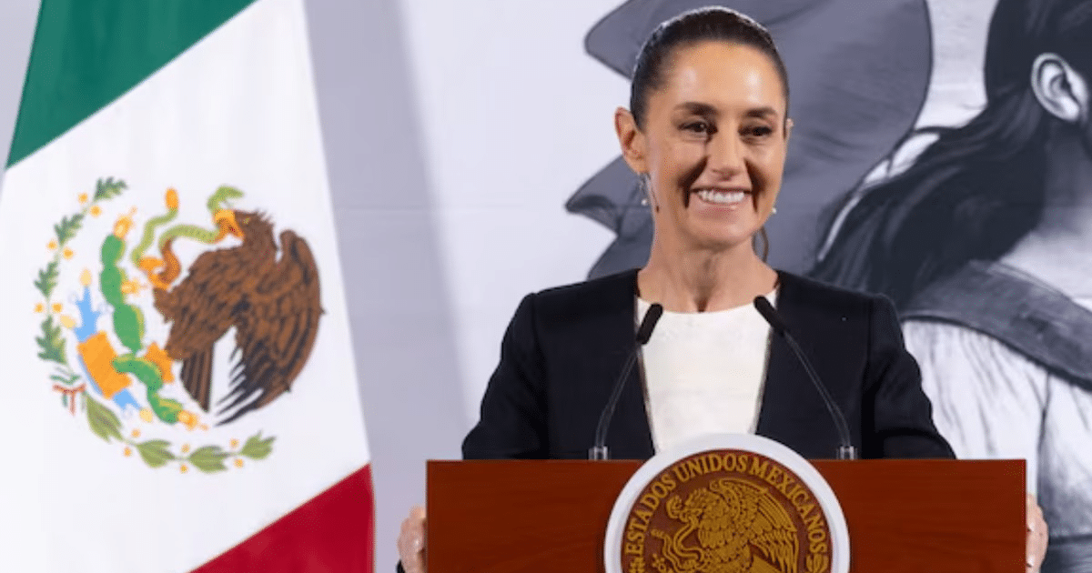 Claudia Sheinbaum en conferencia sobre T-MEC con bandera de México de fondo