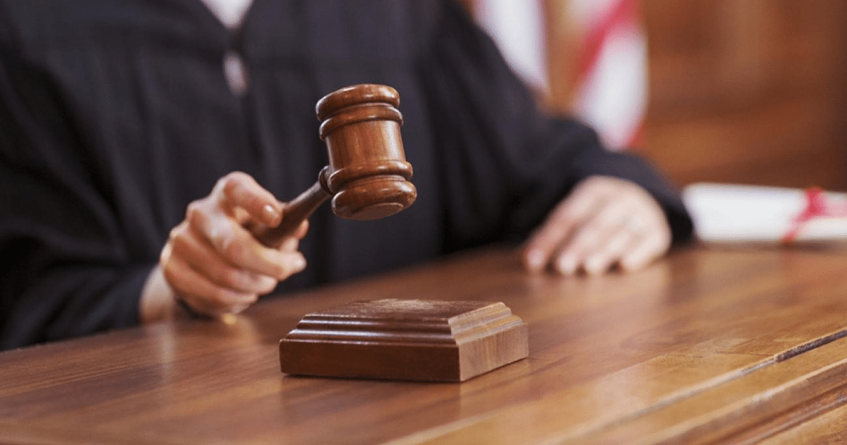 Juez en tribunal con martillo de juez, simbolizando autoridad en procedimientos legales.