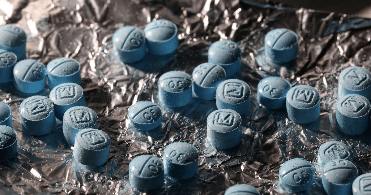 Pastillas azules sobre papel de aluminio, representando la crisis del fentanilo en EE.UU.