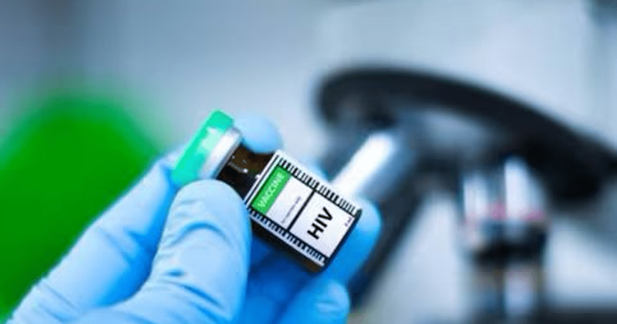 Frasco con etiqueta 'HIV' sostenido por una mano enguantada en un laboratorio, con un microscopio al fondo.