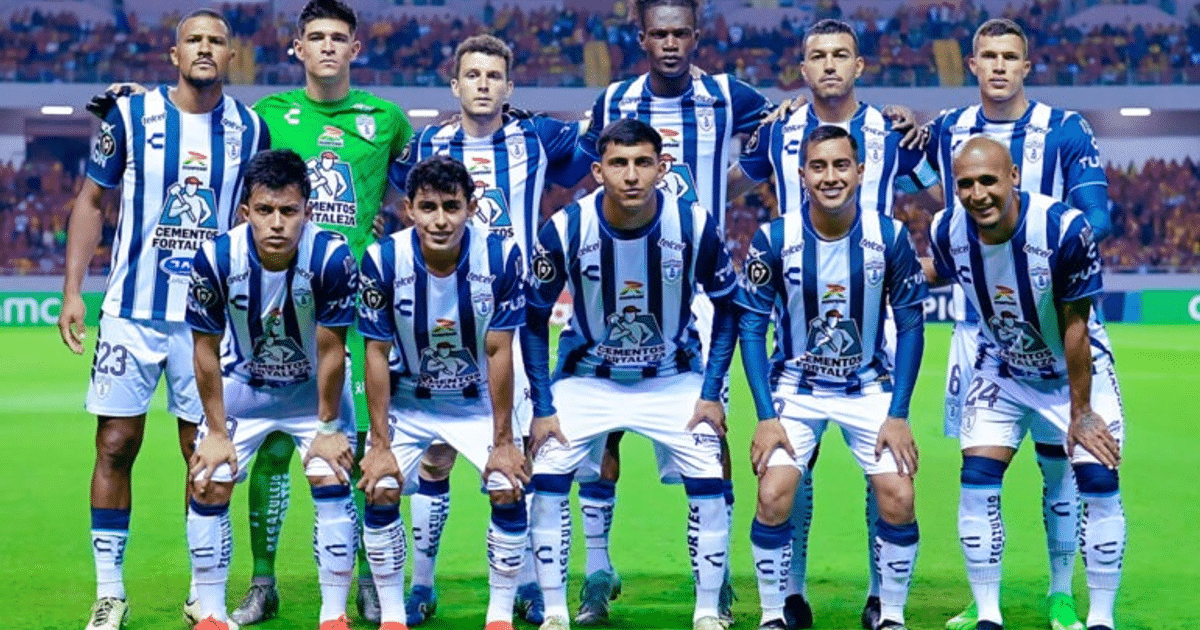 Equipo de fútbol del Grupo Pachuca posando en el estadio con camisetas a rayas blancas y azules.