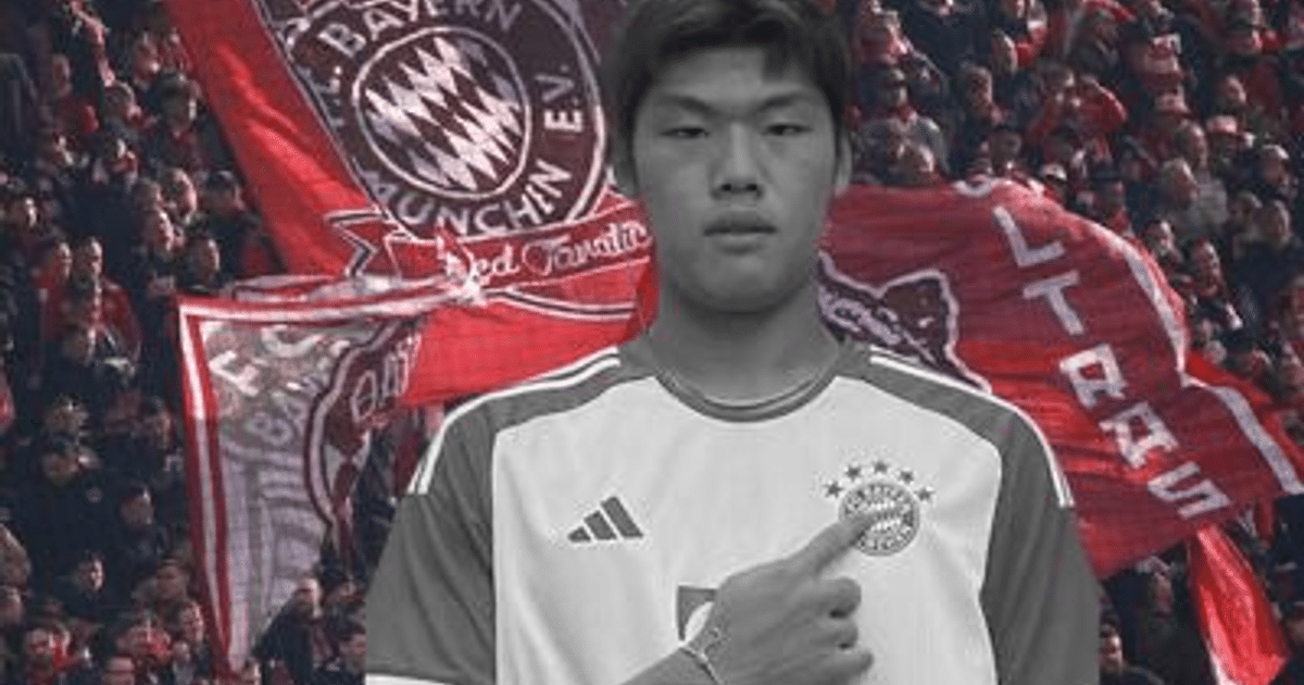 Jugador del Bayern de Múnich señalando el escudo, rodeado de aficionados con banderas del club en blanco y negro.