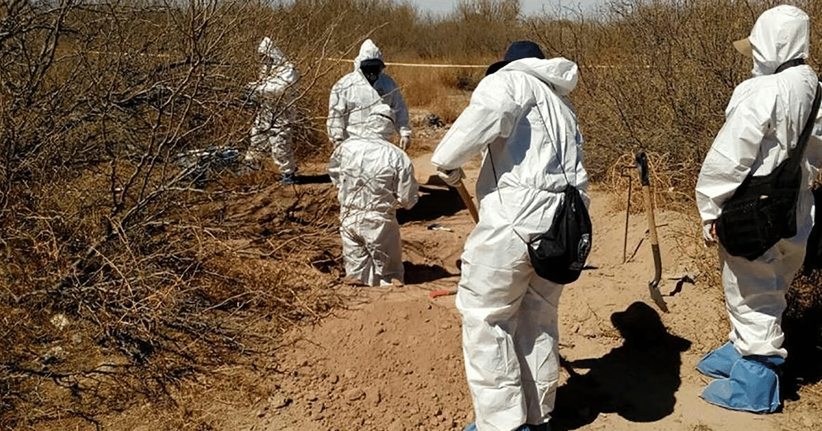 Personas con trajes de protección excavando en un área desértica de Tlajomulco, Jalisco.