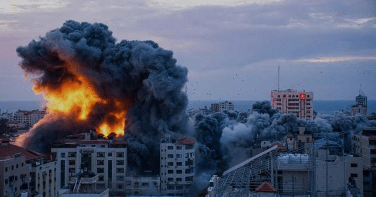 Explosión en zona urbana al atardecer, con humo y llamas, en el contexto del conflicto entre Hamás e Israel.
