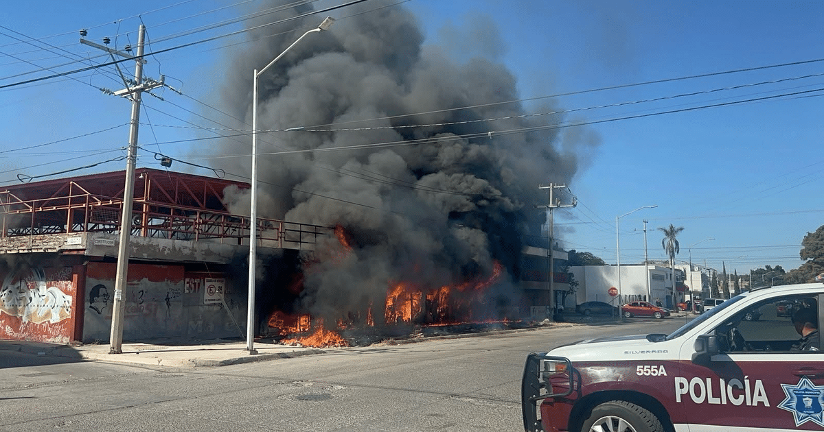 Edificio en llamas con humo negro y vehículo de policía en Los Mochis