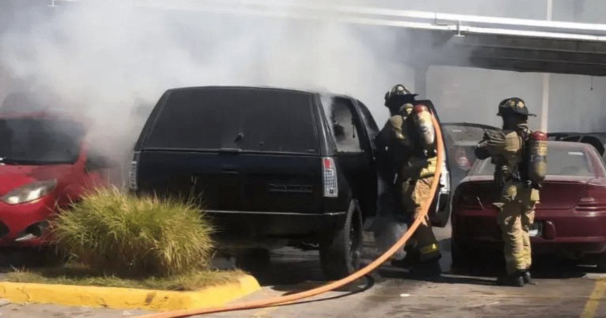Bomberos apagando incendio en camioneta Chevrolet negra en Mazatlán