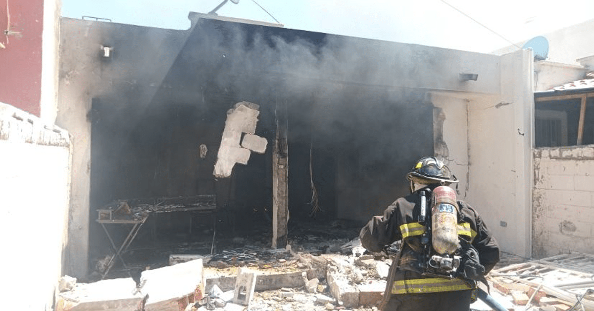Bombero con equipo de protección frente a edificio quemado en Santa Fe