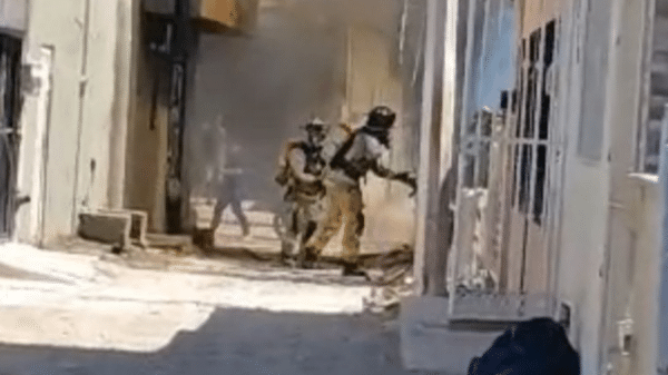 Bomberos respondiendo a una emergencia en un área urbana con humo.