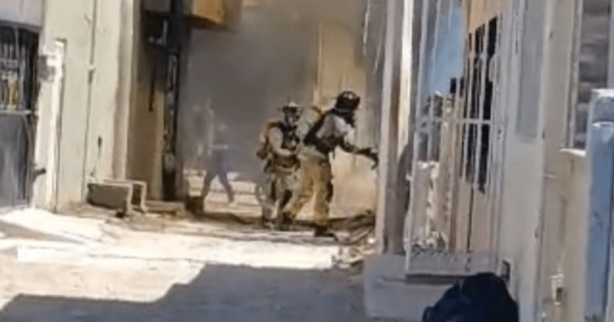 Bomberos respondiendo a una emergencia en un área urbana con humo.