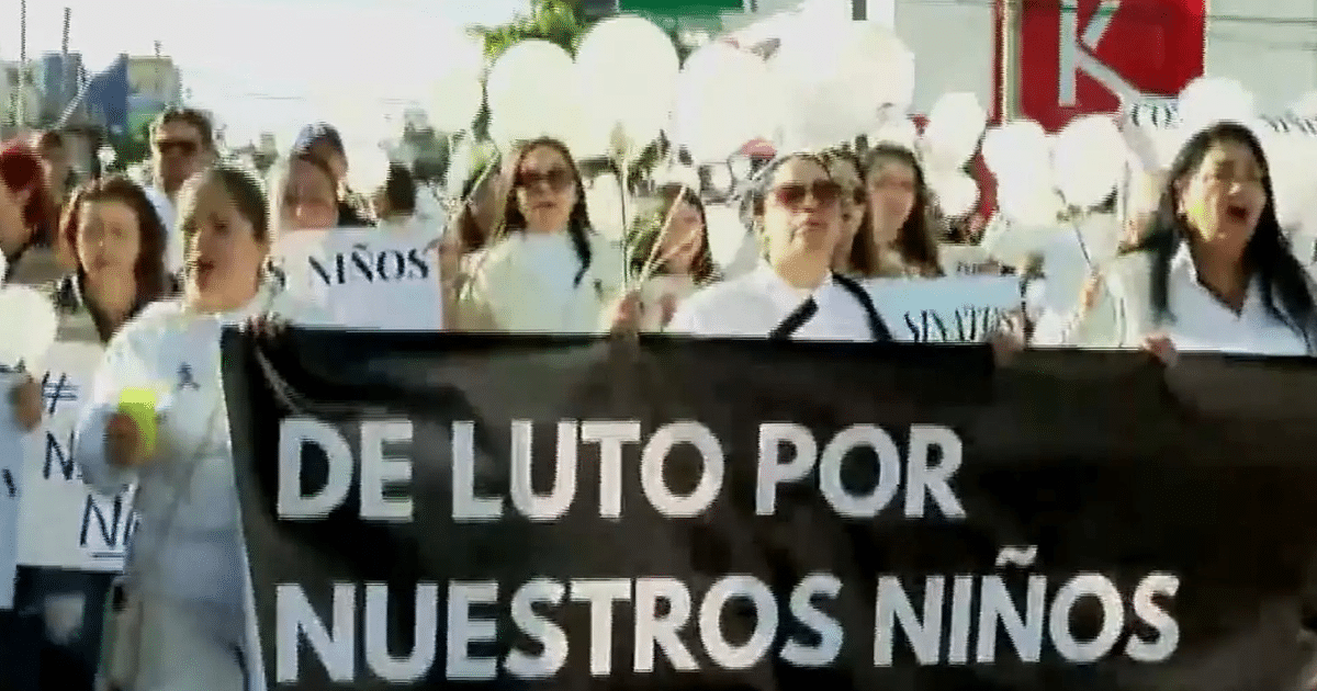 Manifestación en Sinaloa con personas sosteniendo globos blancos y un cartel que dice 'DE LUTO POR NUESTROS NIÑOS'.