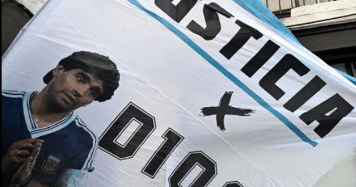 Bandera con fondo blanco y azul con las palabras 'JUSTICIA' y 'D10S', en homenaje a Diego Maradona.