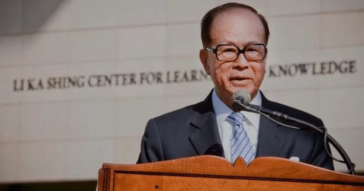 Hombre en traje frente al Li Ka Shing Center durante un evento.