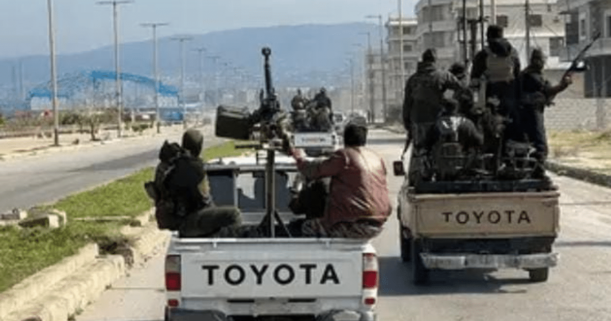 Camionetas Toyota con ocupantes armados en un entorno urbano, posiblemente en una operación militar.