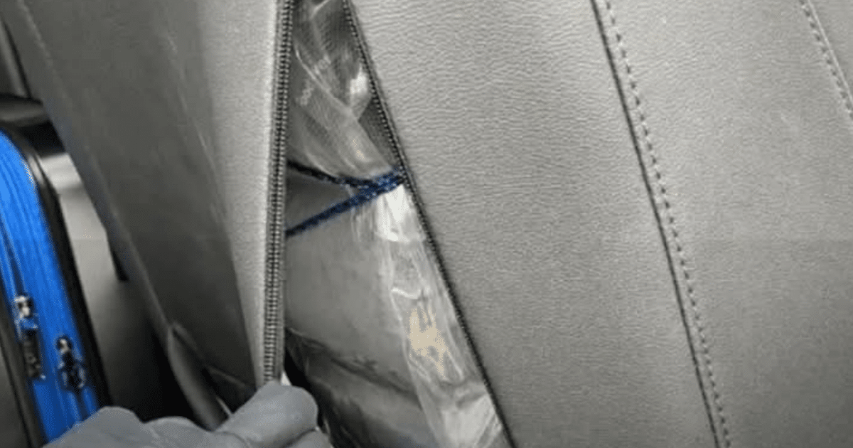 Asiento de vehículo con paquete envuelto en plástico y maleta azul, relacionado con incautación de drogas en Colorado.