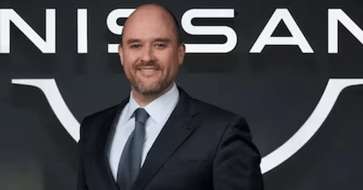 Iván Espinosa, nuevo CEO de Nissan, sonriendo en un evento con el logotipo de Nissan de fondo.