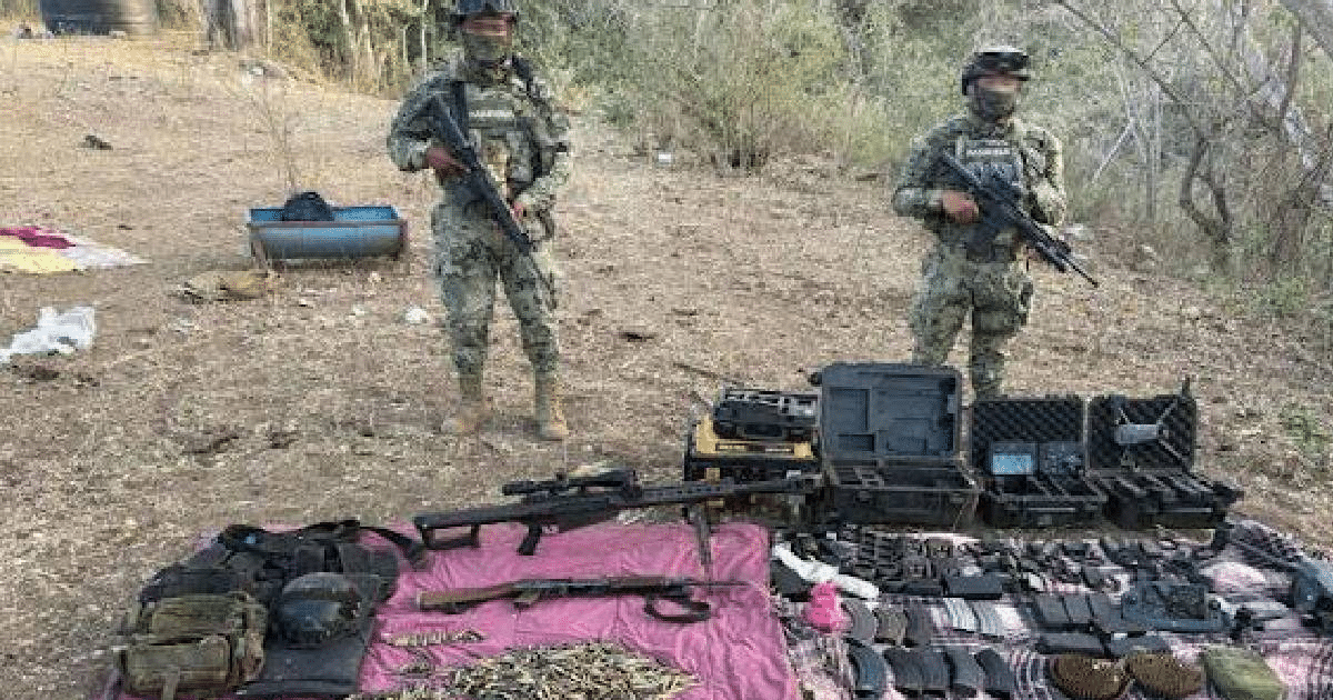 Dos oficiales militares con armas junto a un despliegue de armamento incautado durante el operativo Frontera Norte.