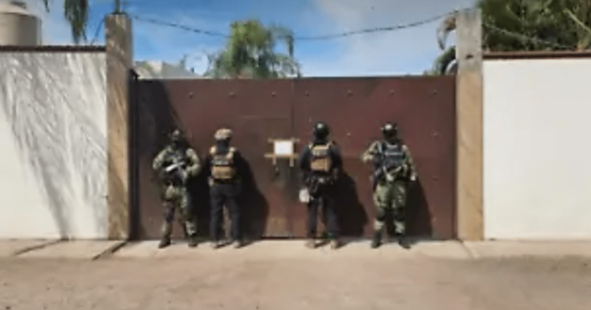 Cuatro agentes tácticos frente a una puerta durante un operativo en Culiacán