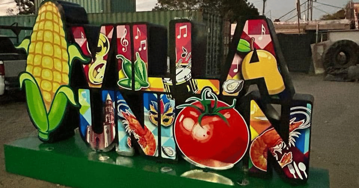 Letrero colorido de Villa Unión con iconos culturales y gastronómicos en un entorno exterior.