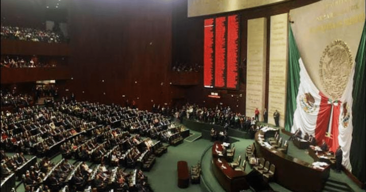 Interior de la Cámara de Diputados en México durante el debate sobre reformas a la Ley de Hidrocarburos, con legisladores y la bandera nacional visible.