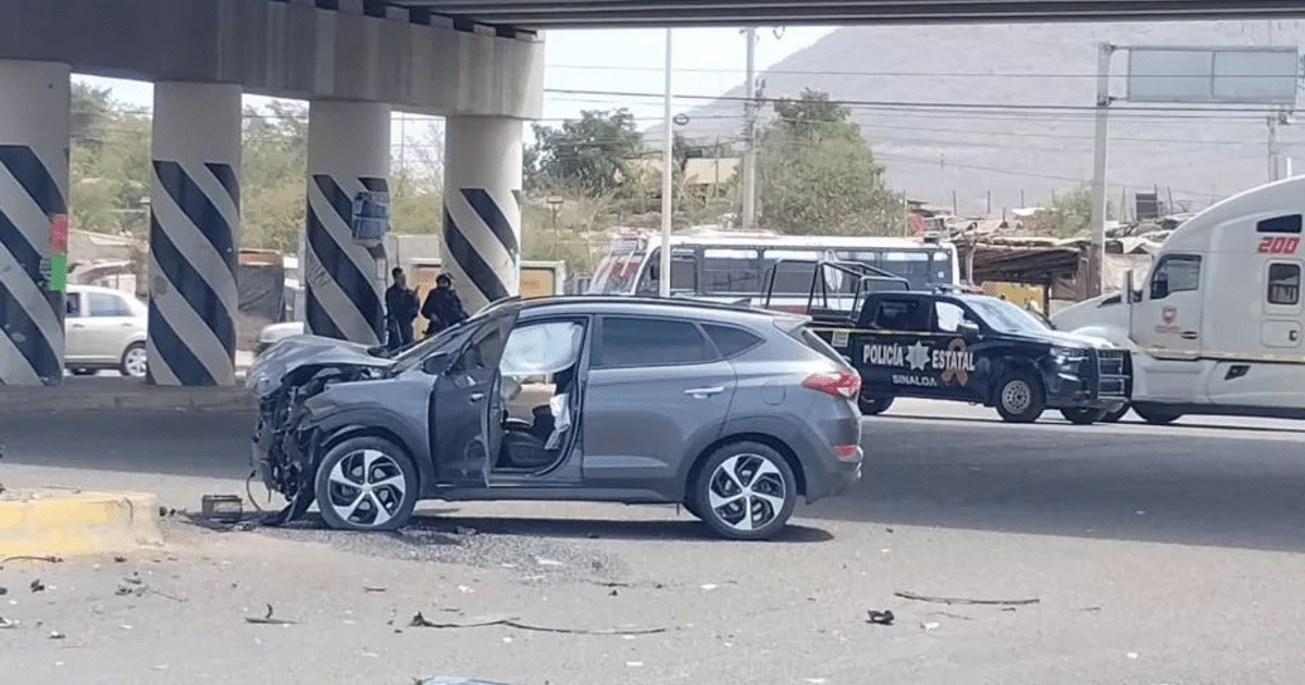 Accidente automovilístico bajo un puente con vehículo gris dañado y presencia policial.