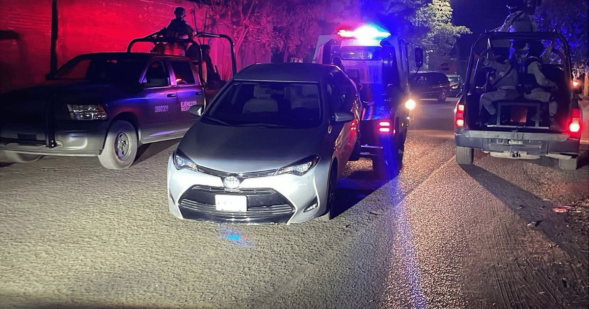 Operativo policial nocturno en Culiacán con un Toyota Corolla gris detenido y vehículos policiales con luces de emergencia.