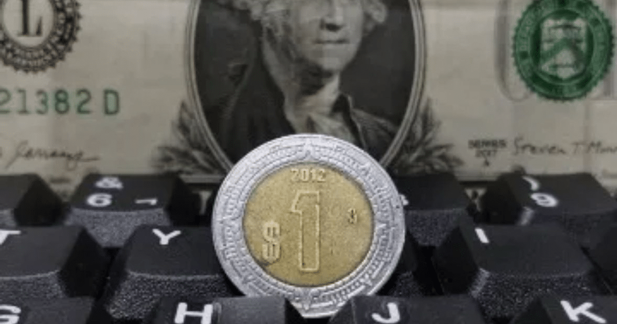 Moneda de un dólar mexicano sobre teclado con billete de dólar estadounidense al fondo