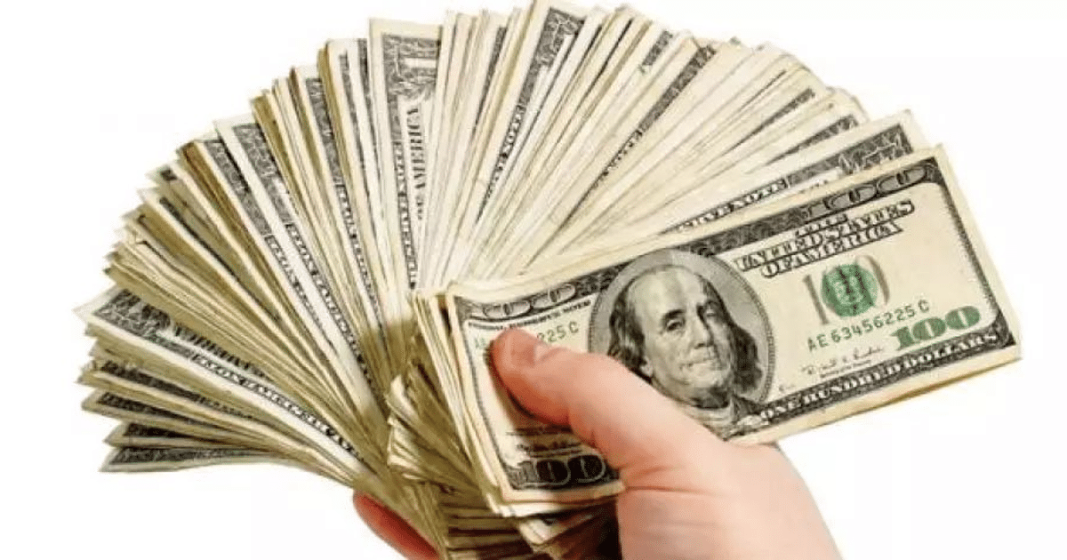 Mano sosteniendo billetes de 100 dólares en abanico, representando el análisis del mercado cambiario en Sinaloa.