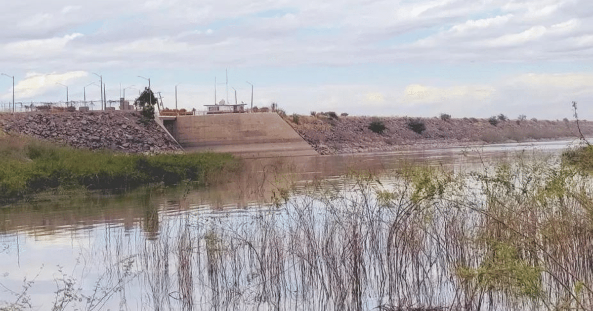 Paisaje acuático con río, vegetación y dique en Sinaloa bajo un cielo nublado.
