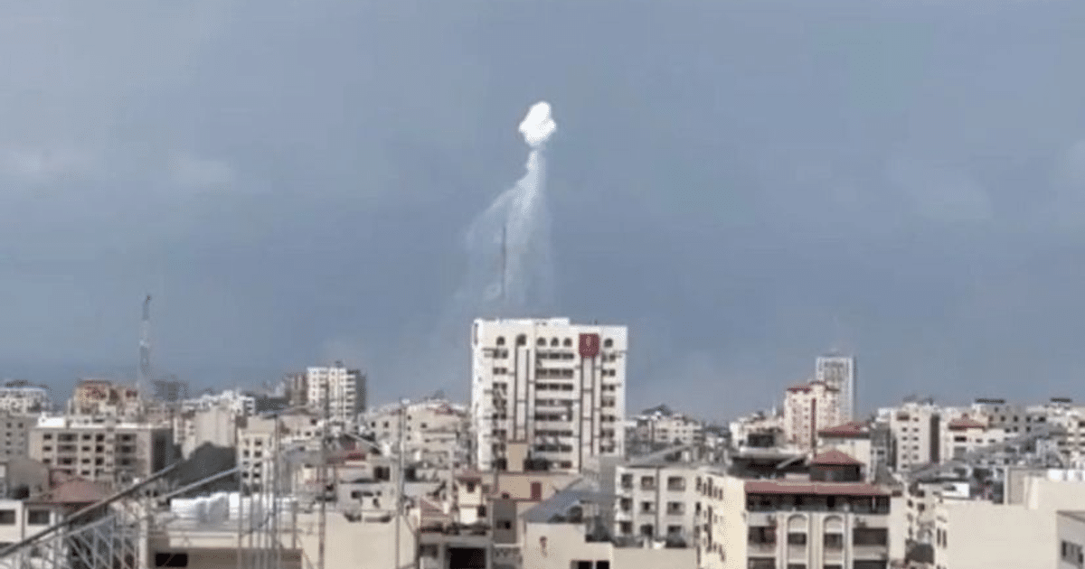 Vista urbana con edificios y formación de humo en el cielo nublado