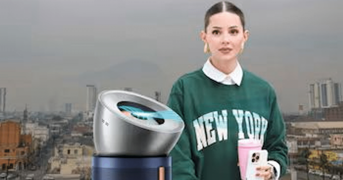 Mujer con suéter 'NEW YORK' y purificador Dyson en ciudad nublada