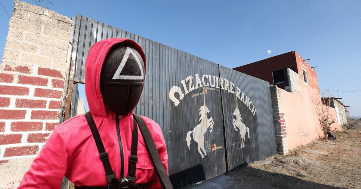 Figura enmascarada con traje rosa frente a Izaguirre Ranch, simbolizando control y violencia.
