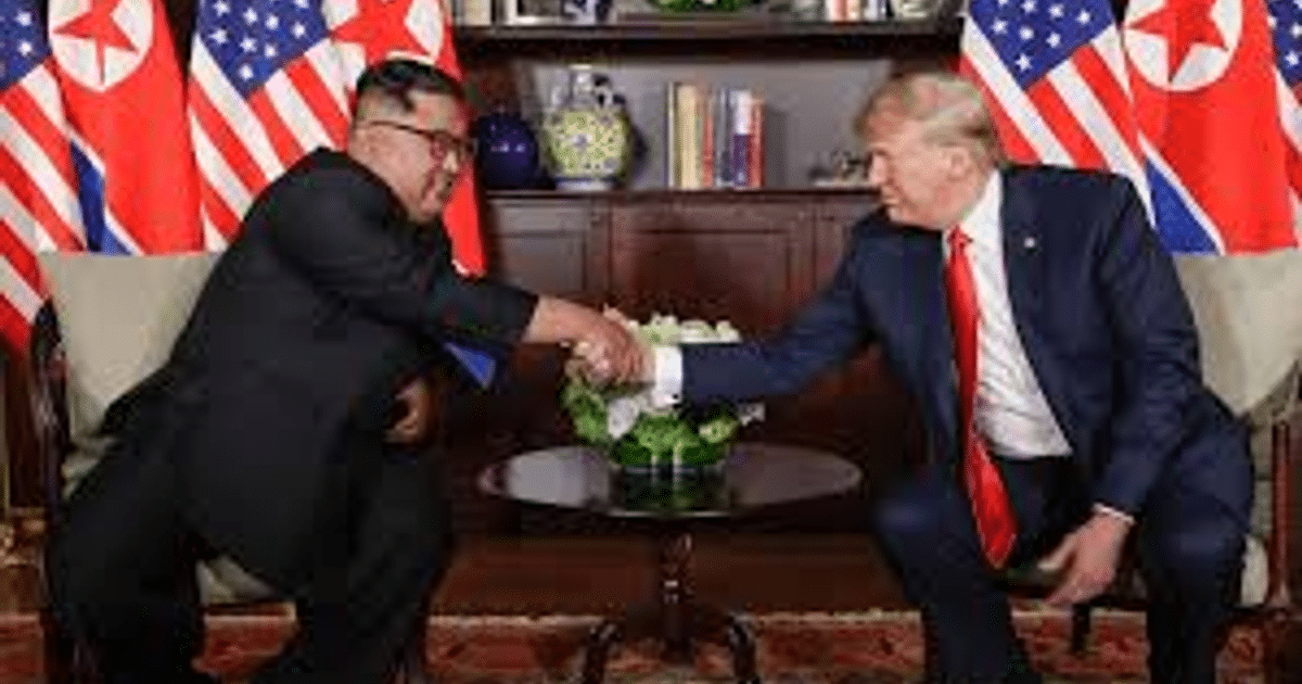 Donald Trump y Kim Jong Un estrechando manos en la Casa Blanca, con banderas de EE.UU. y Corea del Norte de fondo.