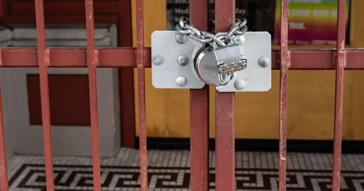Reja de metal roja con candado y cadena, simbolizando la inseguridad en Culiacán.