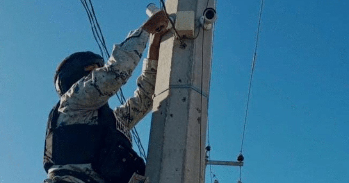 Persona retirando cámaras de videovigilancia de un poste en Culiacán durante un operativo interinstitucional.