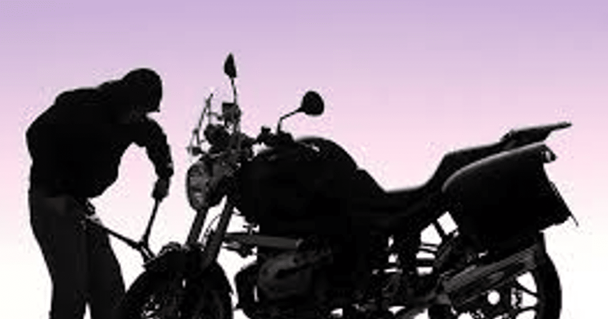 Silueta de una persona trabajando en una motocicleta con fondo de atardecer