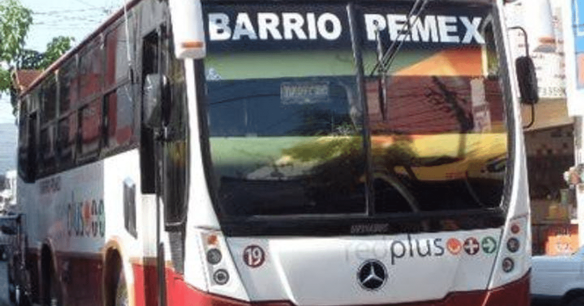 Autobús de transporte público con inscripciones 'BARRIO PEMEX' y 'red plus', estacionado en una calle urbana.