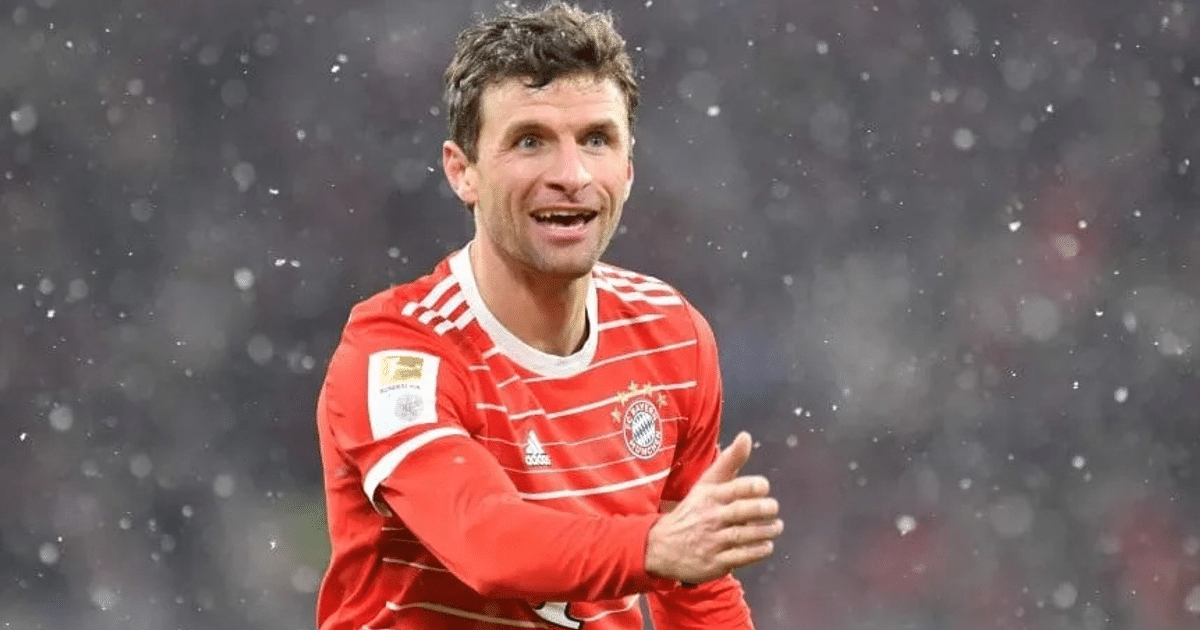 Thomas Müller sonriendo en un campo nevado con la camiseta del Bayern Munich.