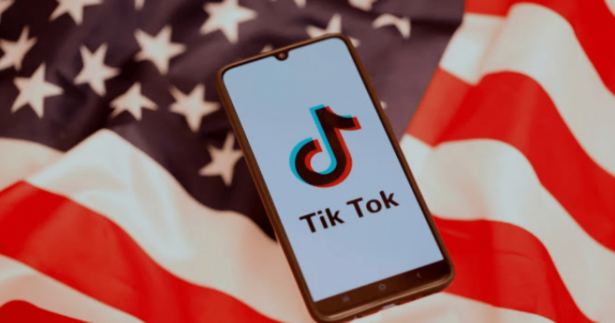 Teléfono móvil con logo de TikTok sobre bandera de EE.UU.