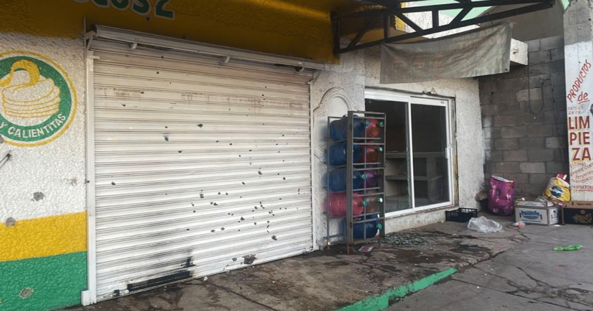 Local comercial con puerta enrollable blanca cerrada, estante con envases, y fachada colorida en Culiacán.