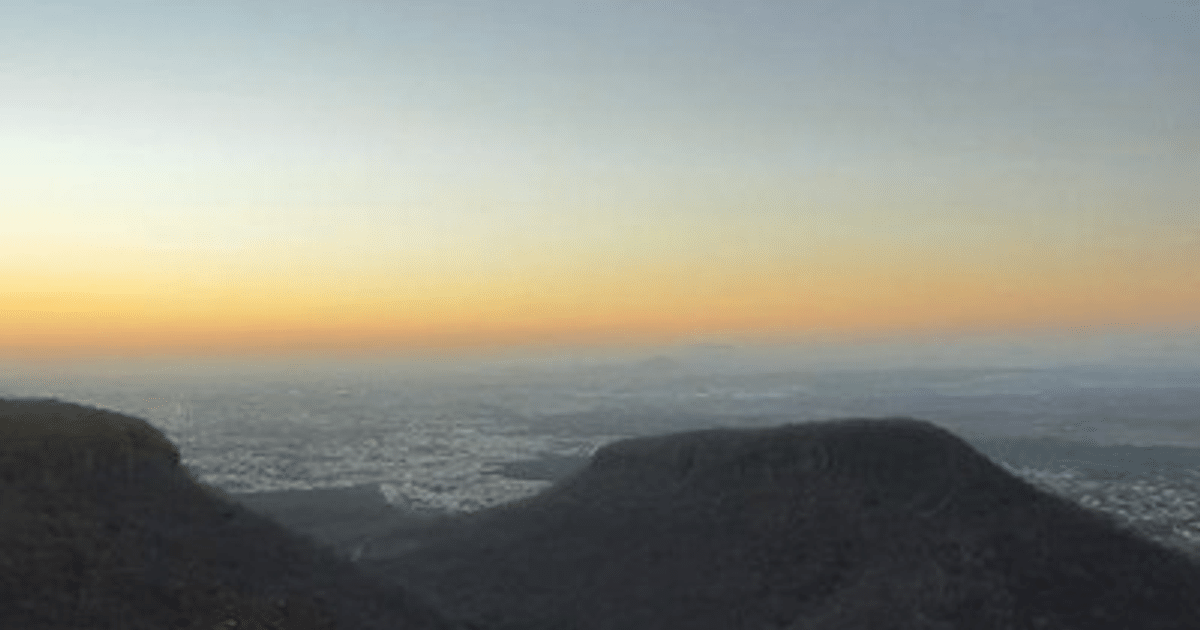 Amanecer en las montañas de Sinaloa con cielo naranja y amarillo, reflejando la transición estacional.