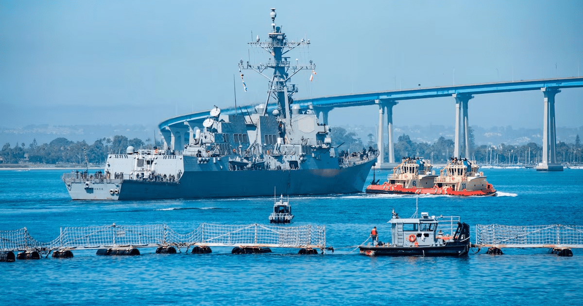 USS Spruance navegando con remolcadores en operación de seguridad marítima