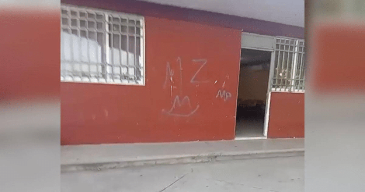 Pared roja con grafitis y una puerta abierta en la Secundaria Técnica No. 72 en Culiacán.