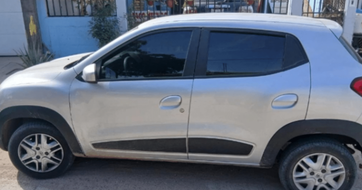 Automóvil plateado estacionado en una calle con fondo de pared azul y plantas, vinculado a operativo policial en Culiacán.