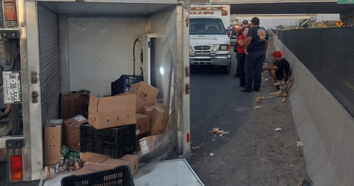 Accidente de tránsito en carretera con vehículo de carga volcado y servicios de emergencia presentes.