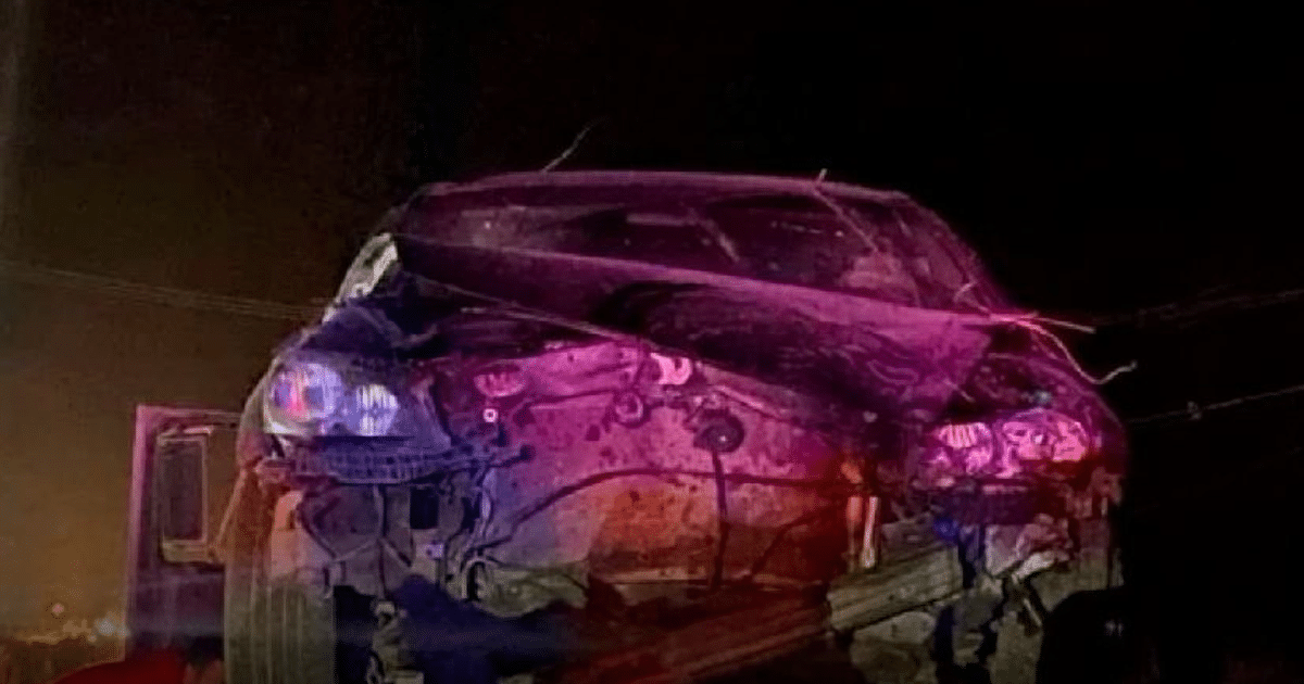 Automóvil dañado en accidente en carretera La 19, Culiacán, con luces de emergencia reflejadas.