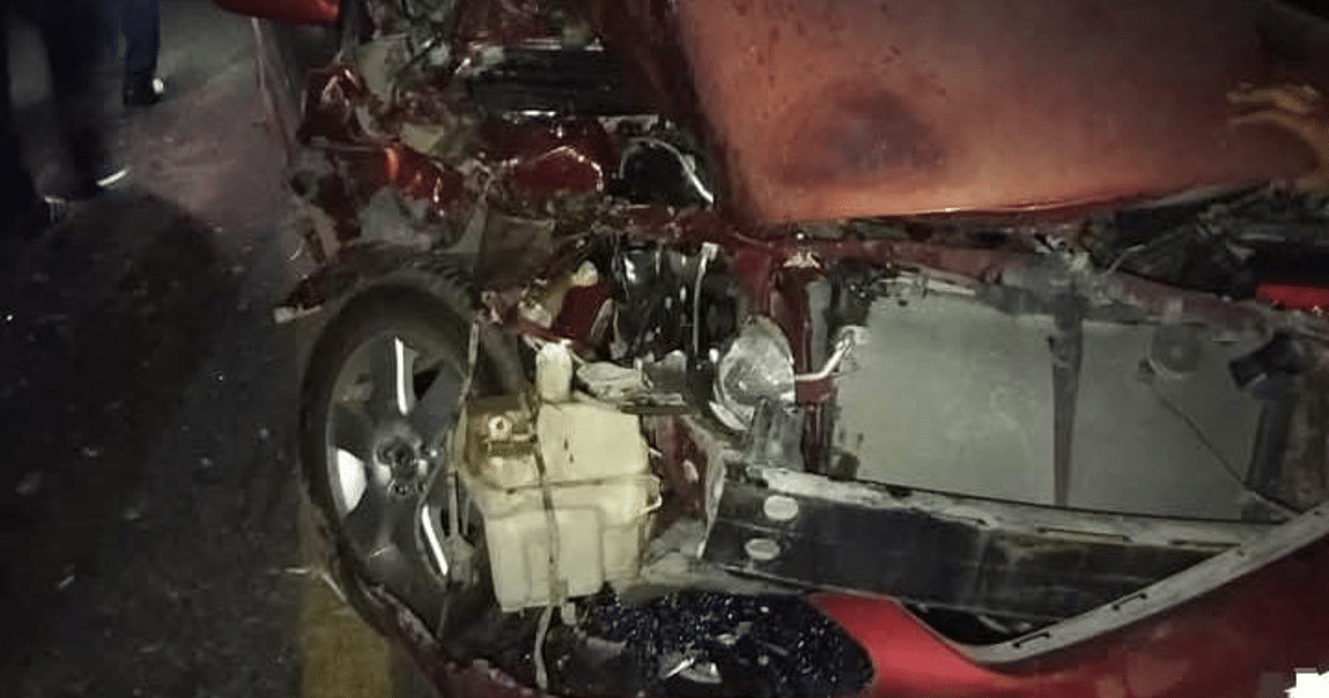 Automóvil dañado en accidente vial en Navolato, con motor expuesto y derrame de líquidos.