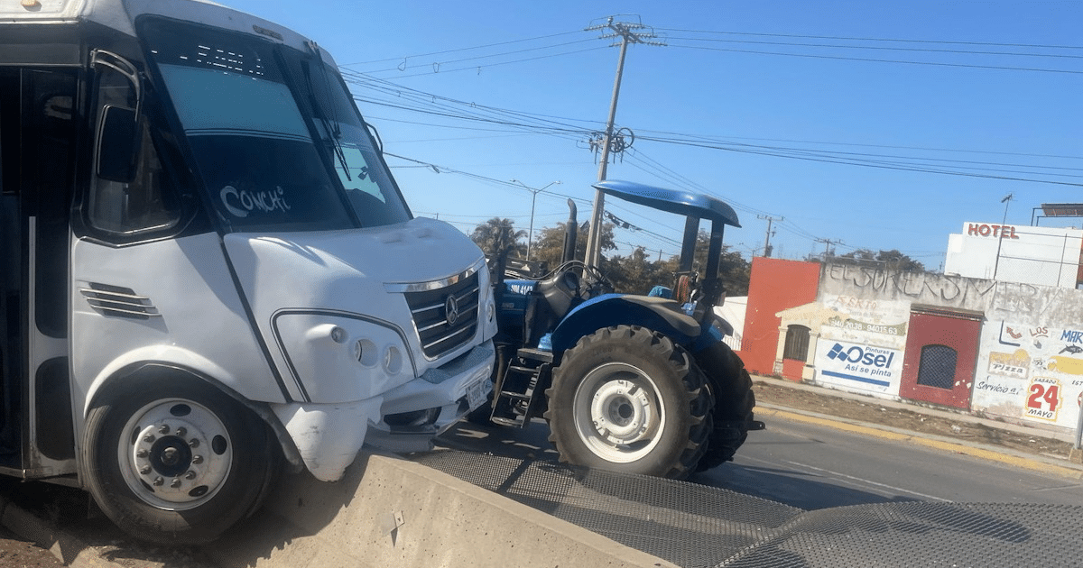 Autobús accidentado en Mazatlán con tractor azul cercano y fondo de edificios